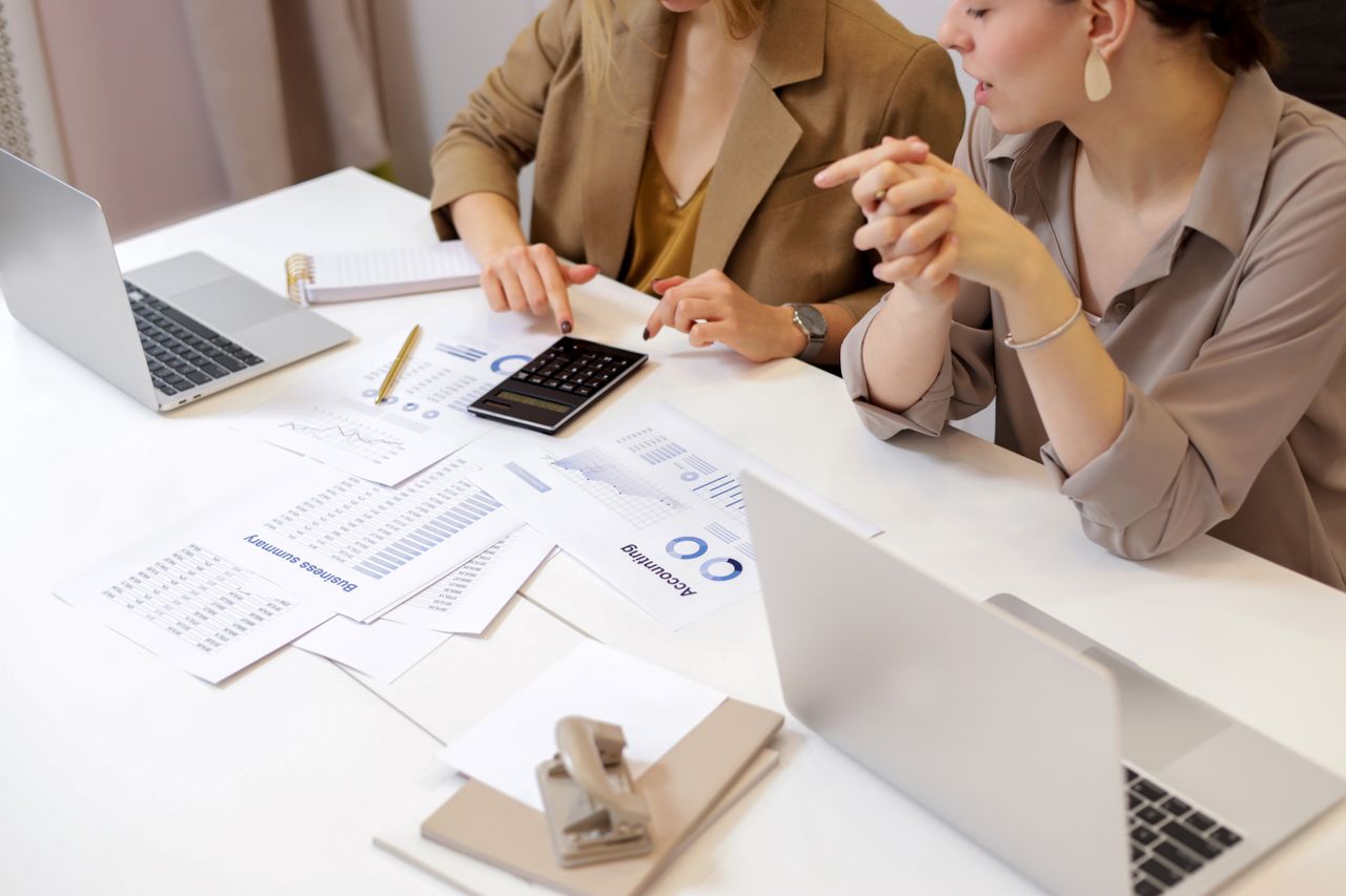 The Art of Drawing Readers In: Your attractive post title goes here Two professionals collaborating on financial documents in a modern office setting.