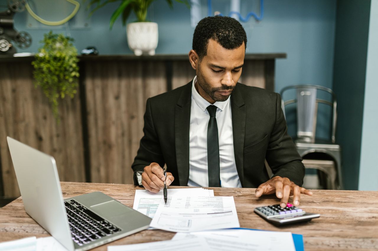 Crafting Captivating Headlines: Your awesome post title goes here A focused businessman works with a calculator and documents in a modern office.